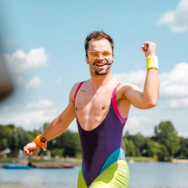 Performer in a purple leotard, fist in the air