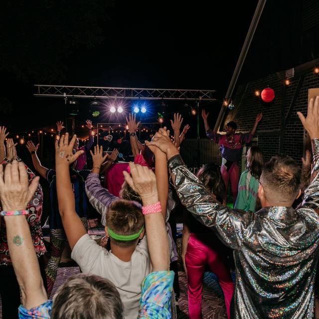 Night crowd with hands in the air under stage lights